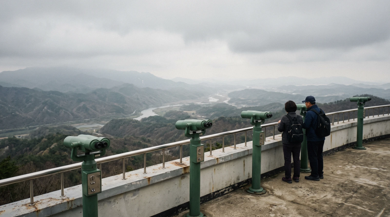 Visitors at the railing of a DMZ observation deck looking north across the border valley, South Korea