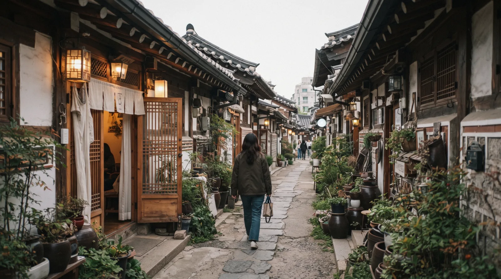 Warm light spilling from a converted hanok doorway in an Ikseon-dong alley, Seoul, South Korea